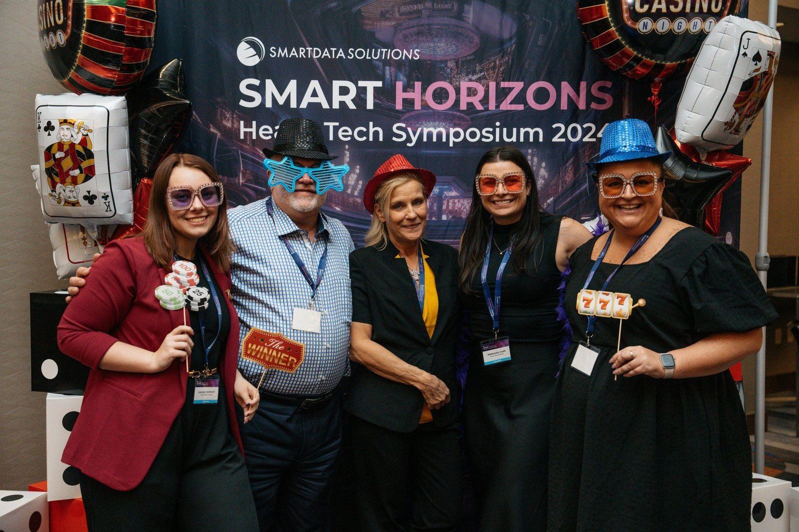 Smiling attendees posing together in front of the Smart Horizons backdrop